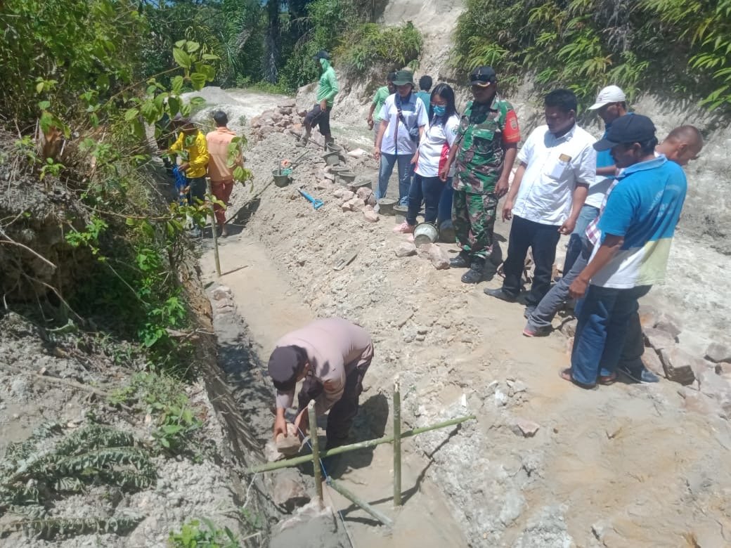 Bhabinkamtibmas Desa Harian Onanrunggu Lakukan Peletakan Batu Pertama Pembangunan Saluran Air